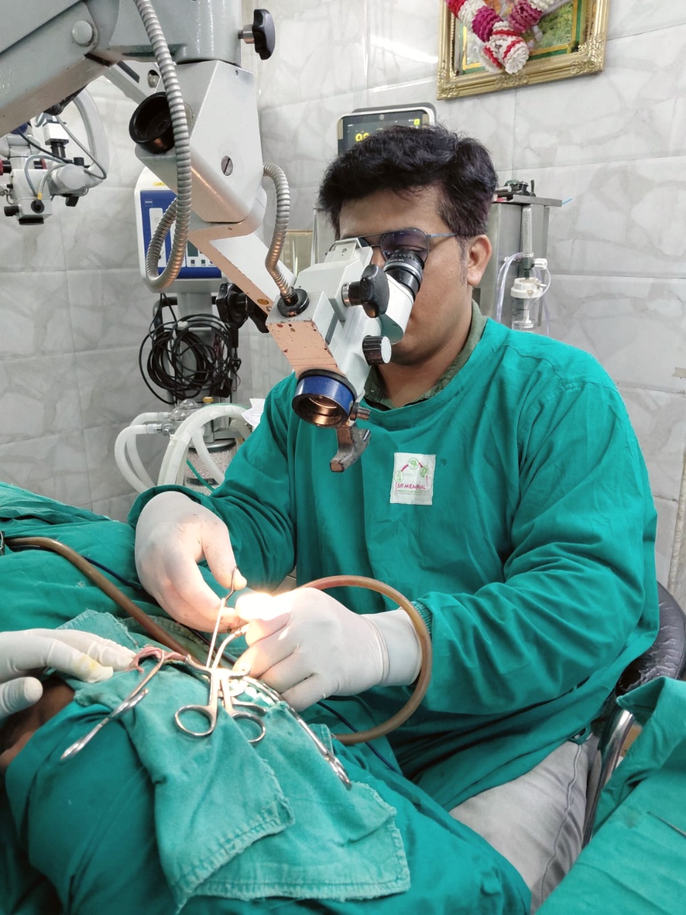 Dr. Kishan operating under the microscope